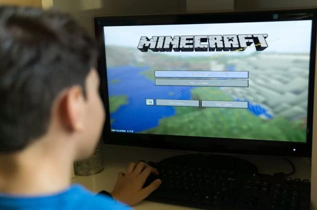 Young boy playing Minecraft on a PC