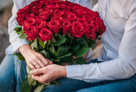 Couple holding a large bouquet of roses