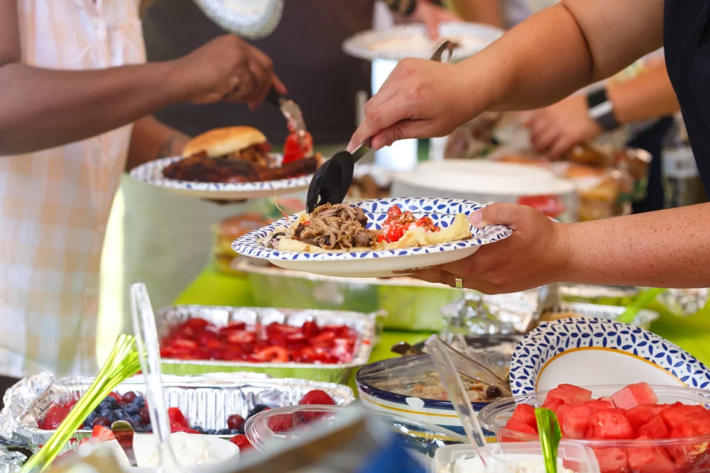 People filling their plates at a potluck