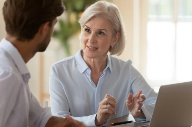 Middle-aged woman mentor giving advice to a younger male mentee