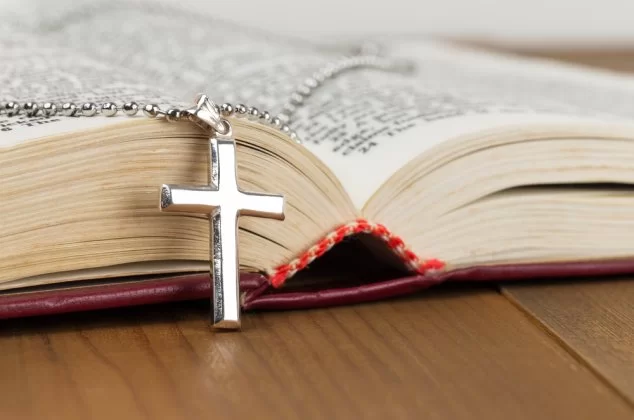 Cross necklace resting on an open bible