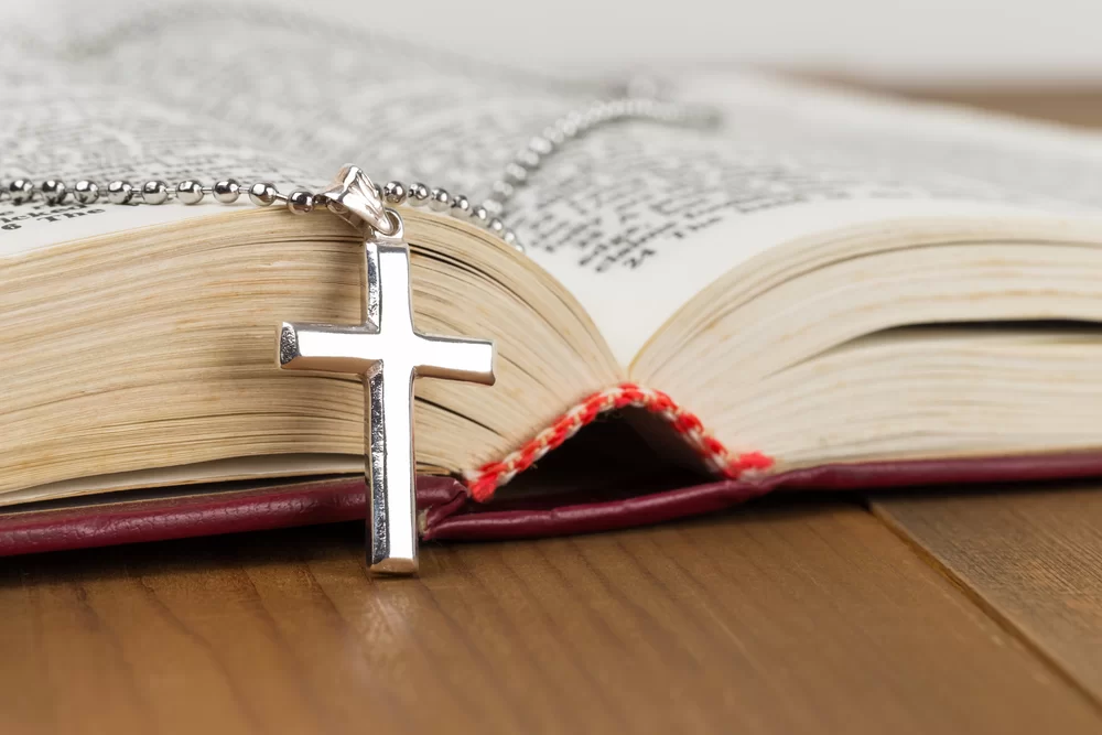 Cross necklace resting on an open bible