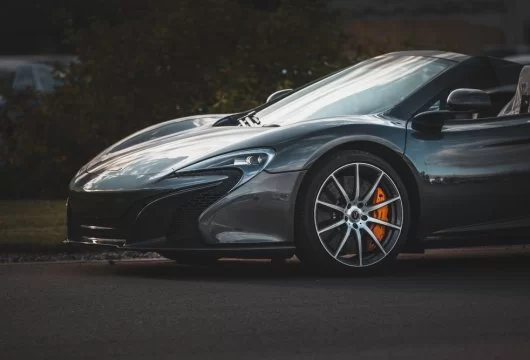 A dark gray, fast sports car on the road