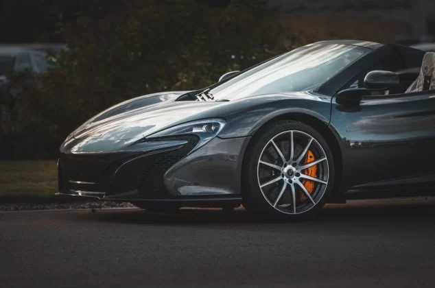 A dark gray, fast sports car on the road