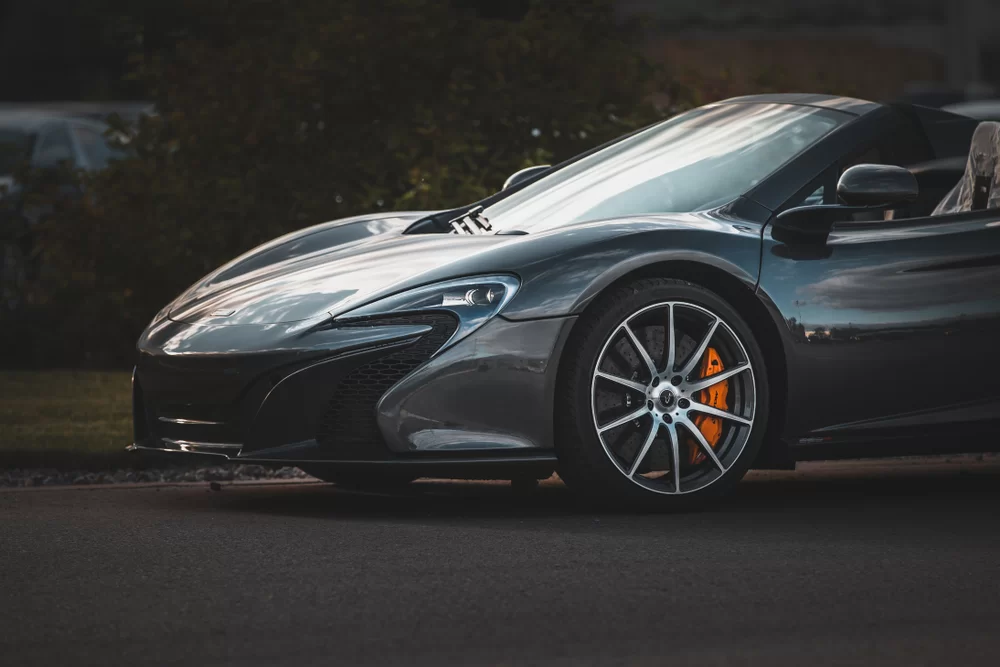 A dark gray, fast sports car on the road