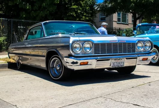 Classic lowrider car parked in front of a house