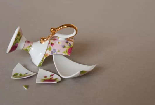 Broken teacup in pieces on the floor