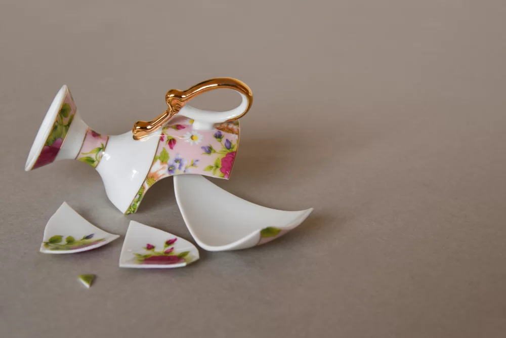 Broken teacup in pieces on the floor