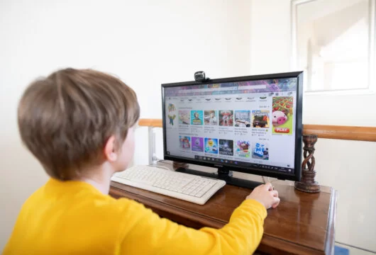 Young boy choosing a Roblox mode like Adopt Me! on a computer