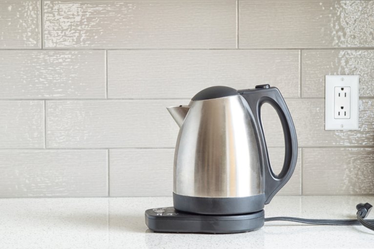 Electric kettle, which starts with "e," on a white kitchen counter