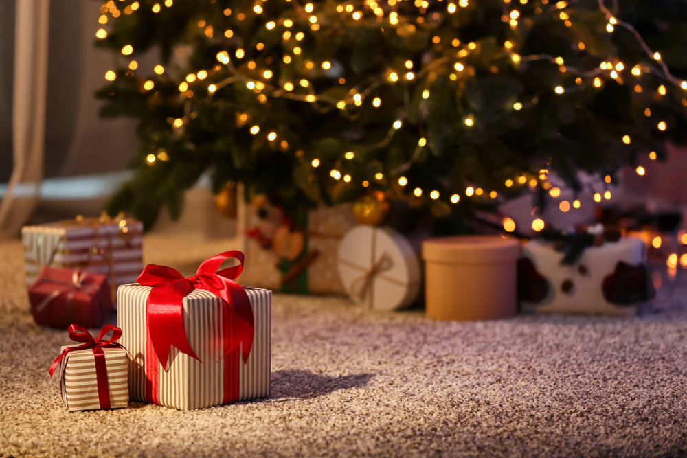 Close-up of wrapped Christmas presents beneath a tree