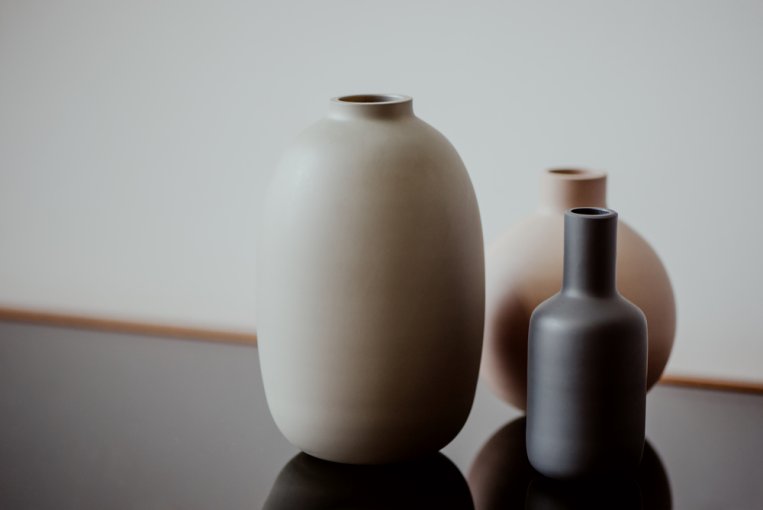 Three vases resting on a dark table