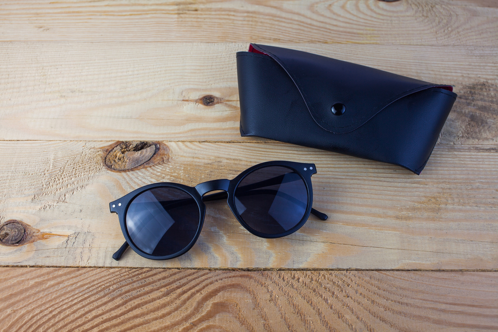 Sunglasses and case resting on a wooden table