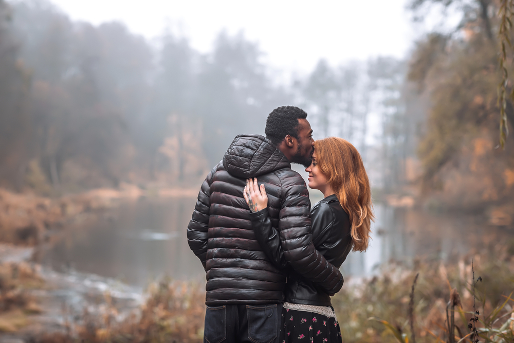 Couple hugging by a pond