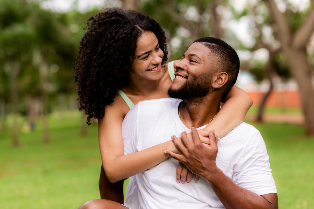 Young couple hugging and smiling in a park