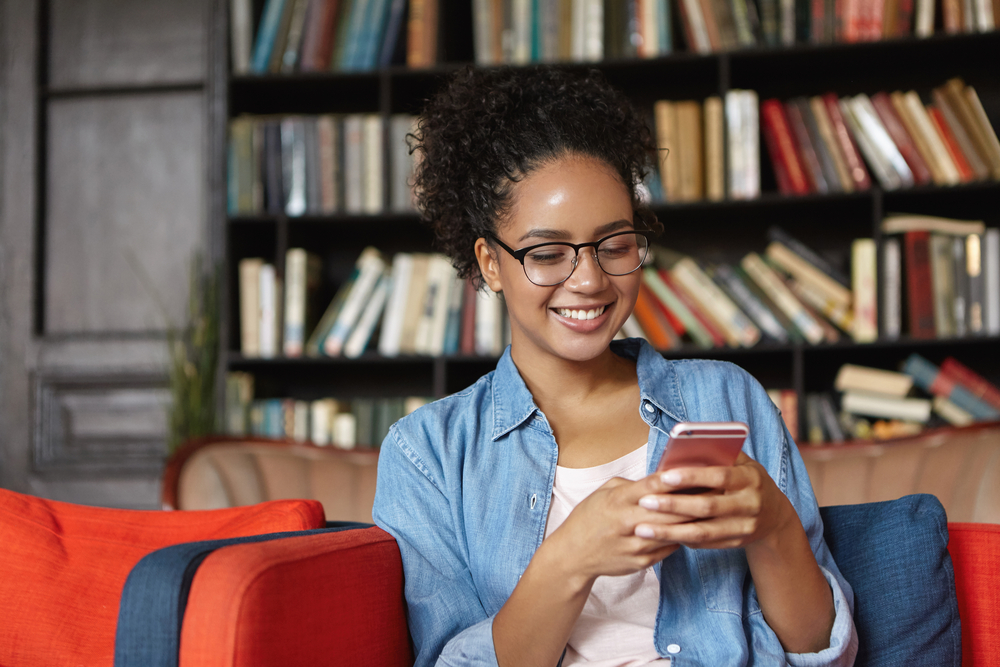 Young woman using smartphone to choose a one-word username