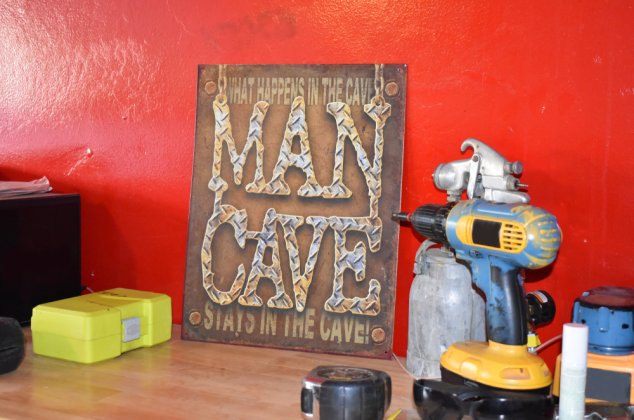 "Man Cave" sign and tools displayed on a wood table