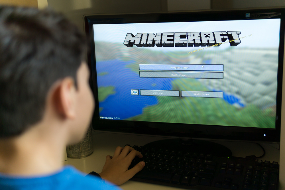 Young boy playing Minecraft on a PC