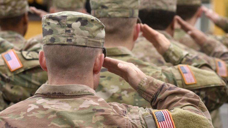 Military service members saluting in uniform