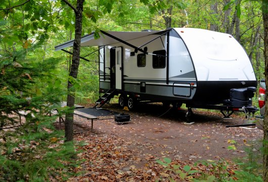 Camper parked in a wooded campsite