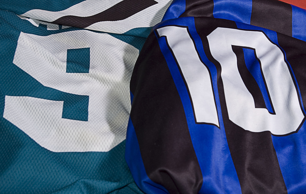 Close-up of a green jersey with the number "9" and blue/black striped jersey with the number "10"