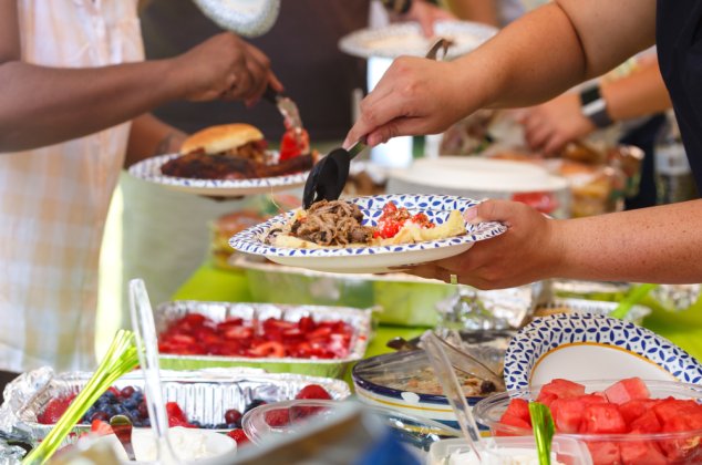 People filling their plates at a potluck