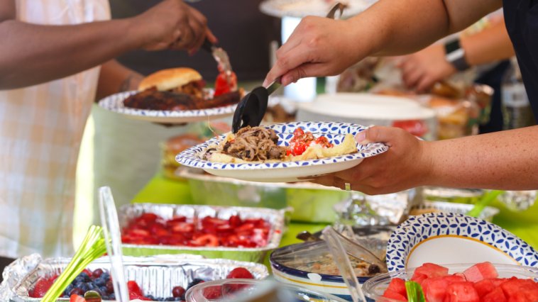 People filling their plates at a potluck