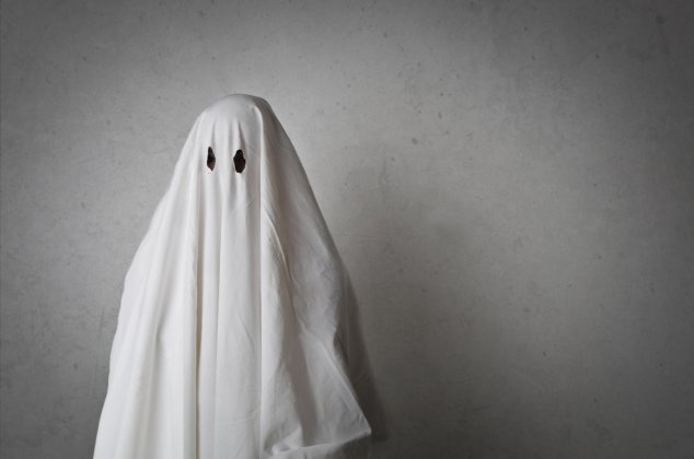 Person wearing a white sheet to look like a ghost