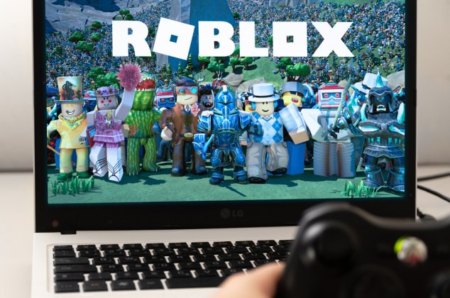 Roblox characters and logo displayed on a laptop computer