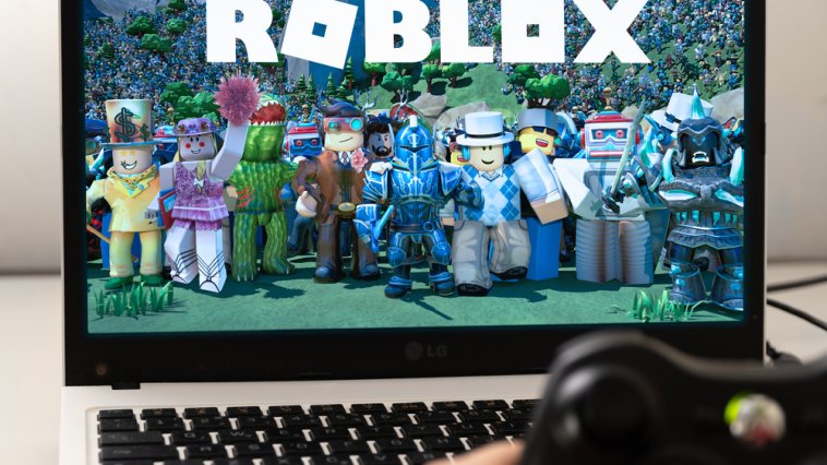 Roblox characters and logo displayed on a laptop computer