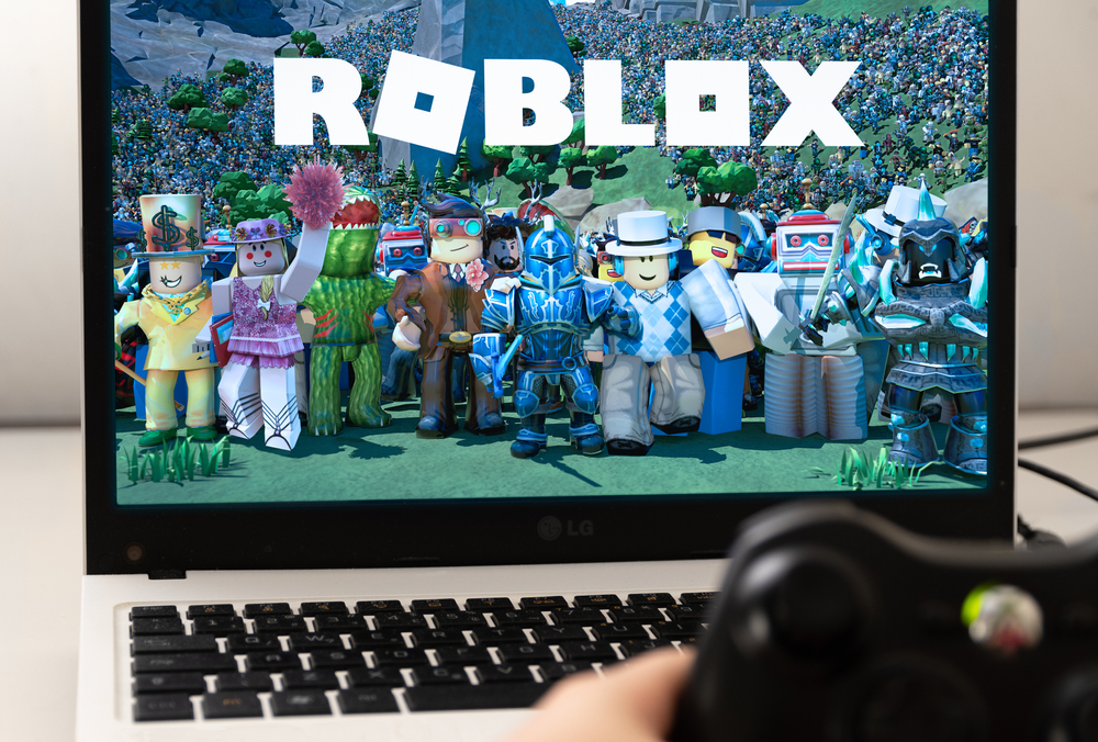 Roblox characters and logo displayed on a laptop computer
