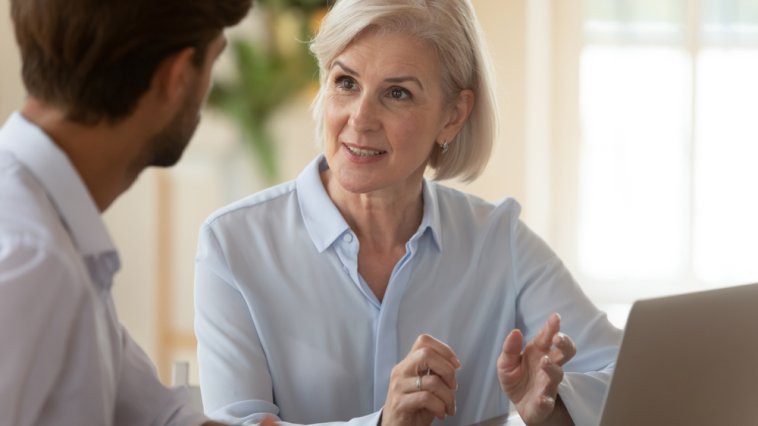 Middle-aged woman mentor giving advice to a younger male mentee