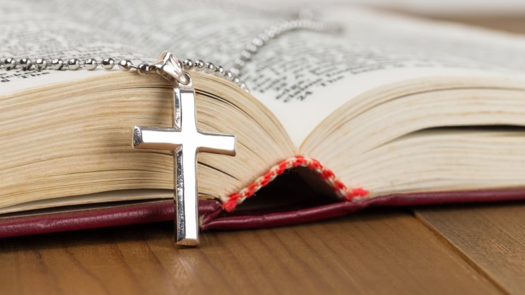 Cross necklace resting on an open bible