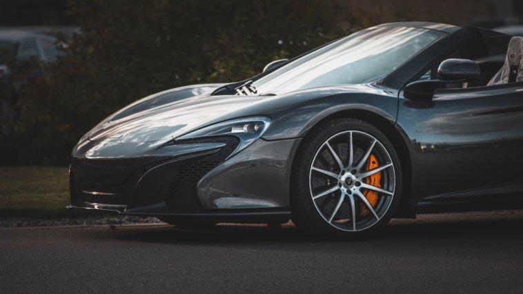 A dark gray, fast sports car on the road