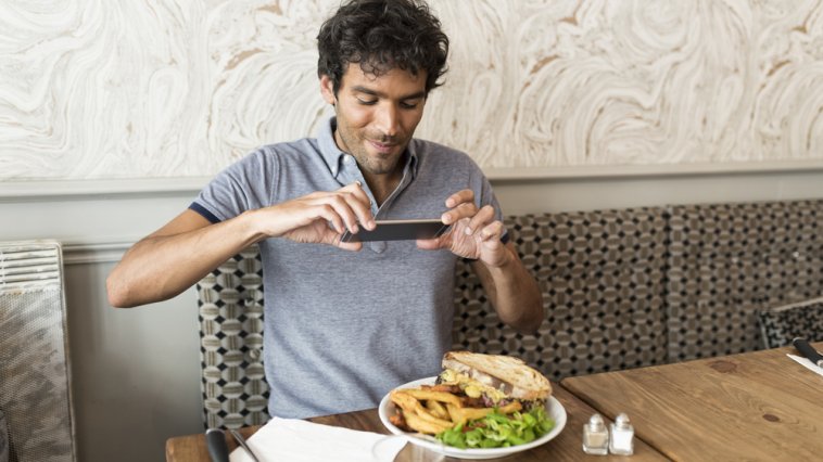 Foodie taking a picture of his plate at a restaurant