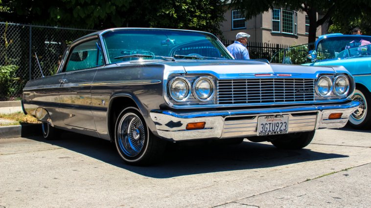 Classic lowrider car parked in front of a house