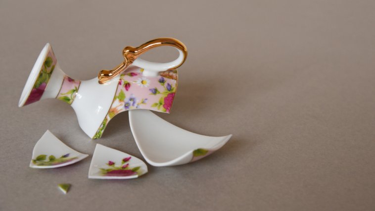 Broken teacup in pieces on the floor