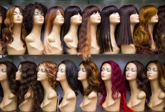 Mannequins wearing wigs in various colors and styles