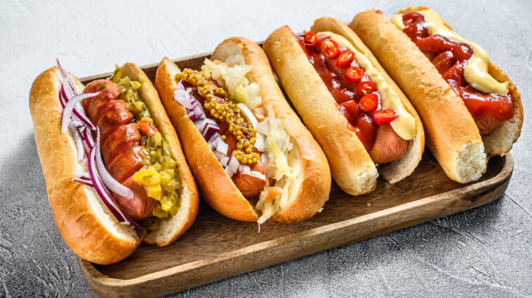 Four hot dogs with different toppings on a platter