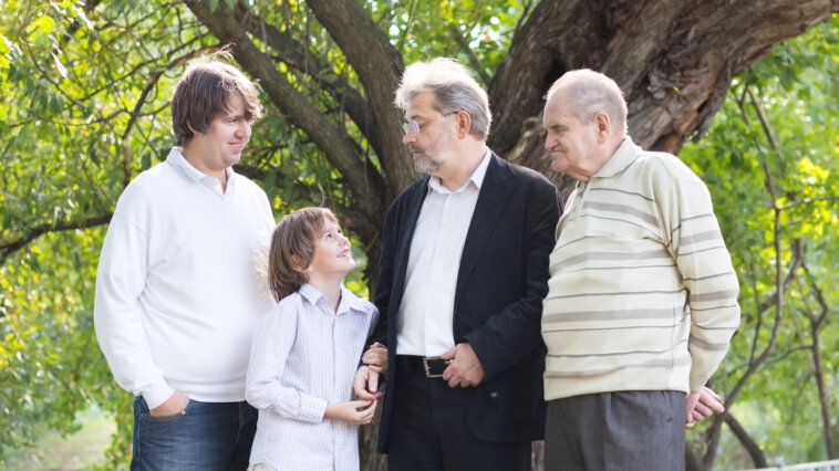 Four generations of family members standing together